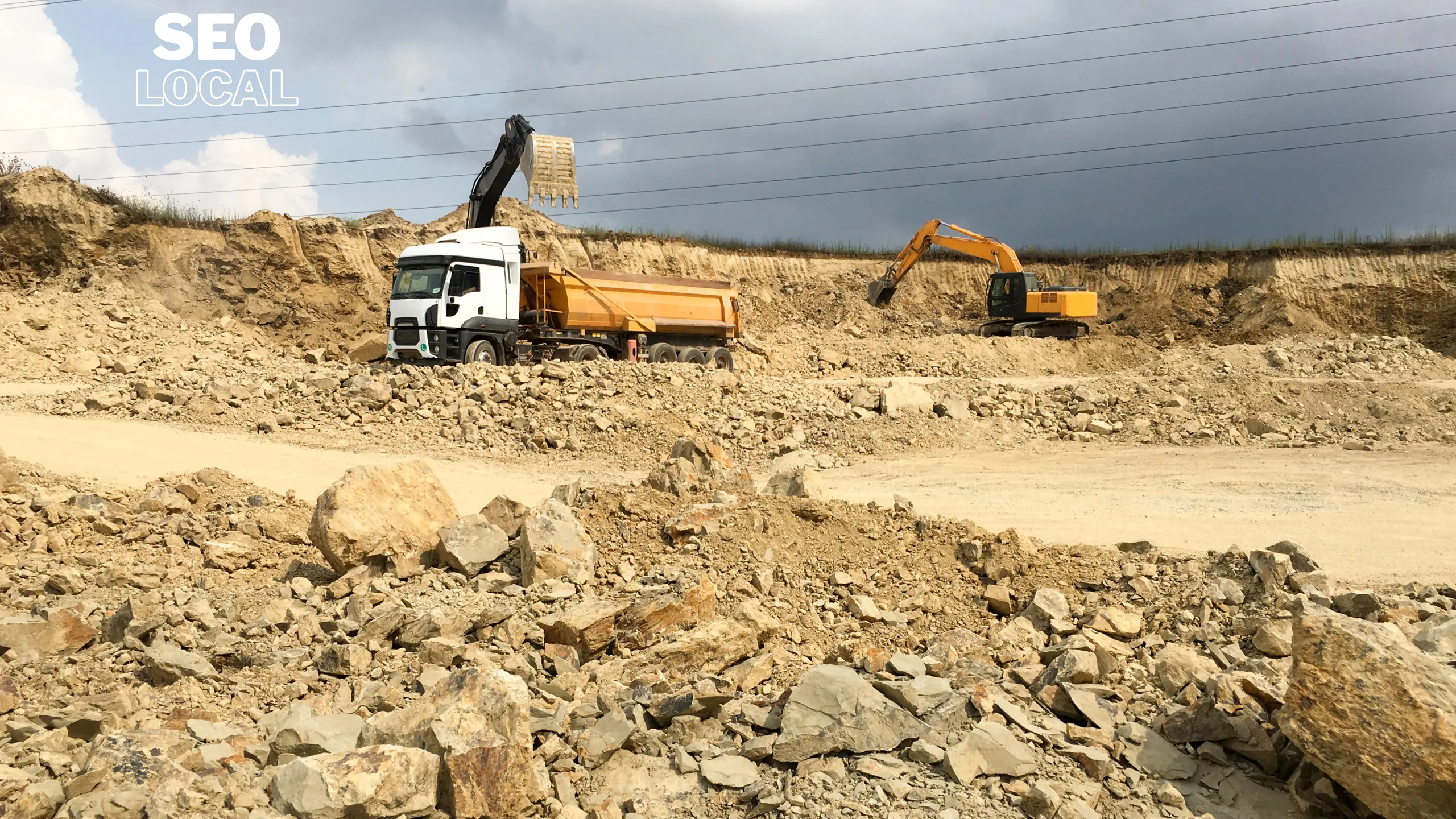 Una volqueta y excavadoras trabajando en un terreno de cantera