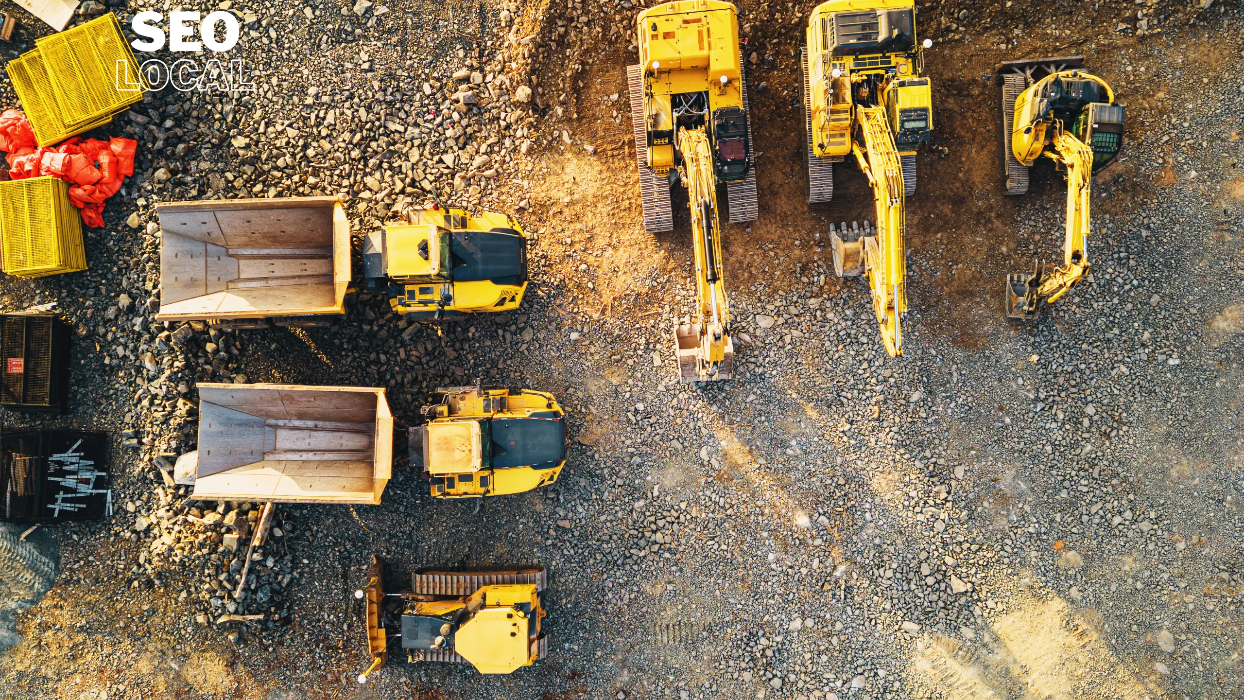 Vista aérea de volquetas y excavadoras amarillas en un terreno de obra