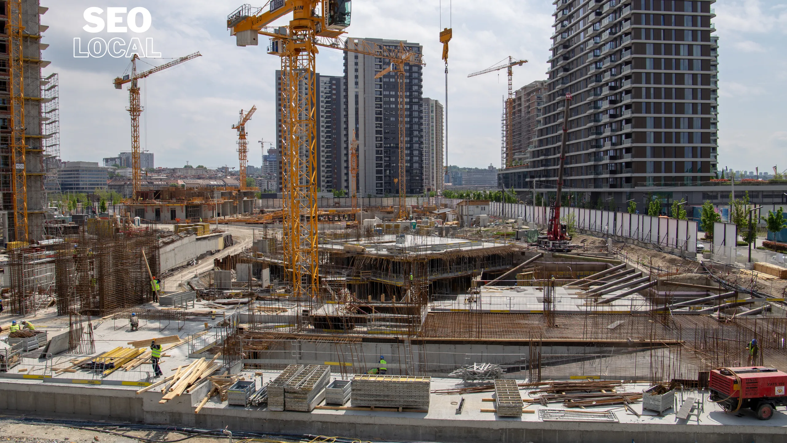 Una obra grande con grúas torre y edificios en construcción al fondo