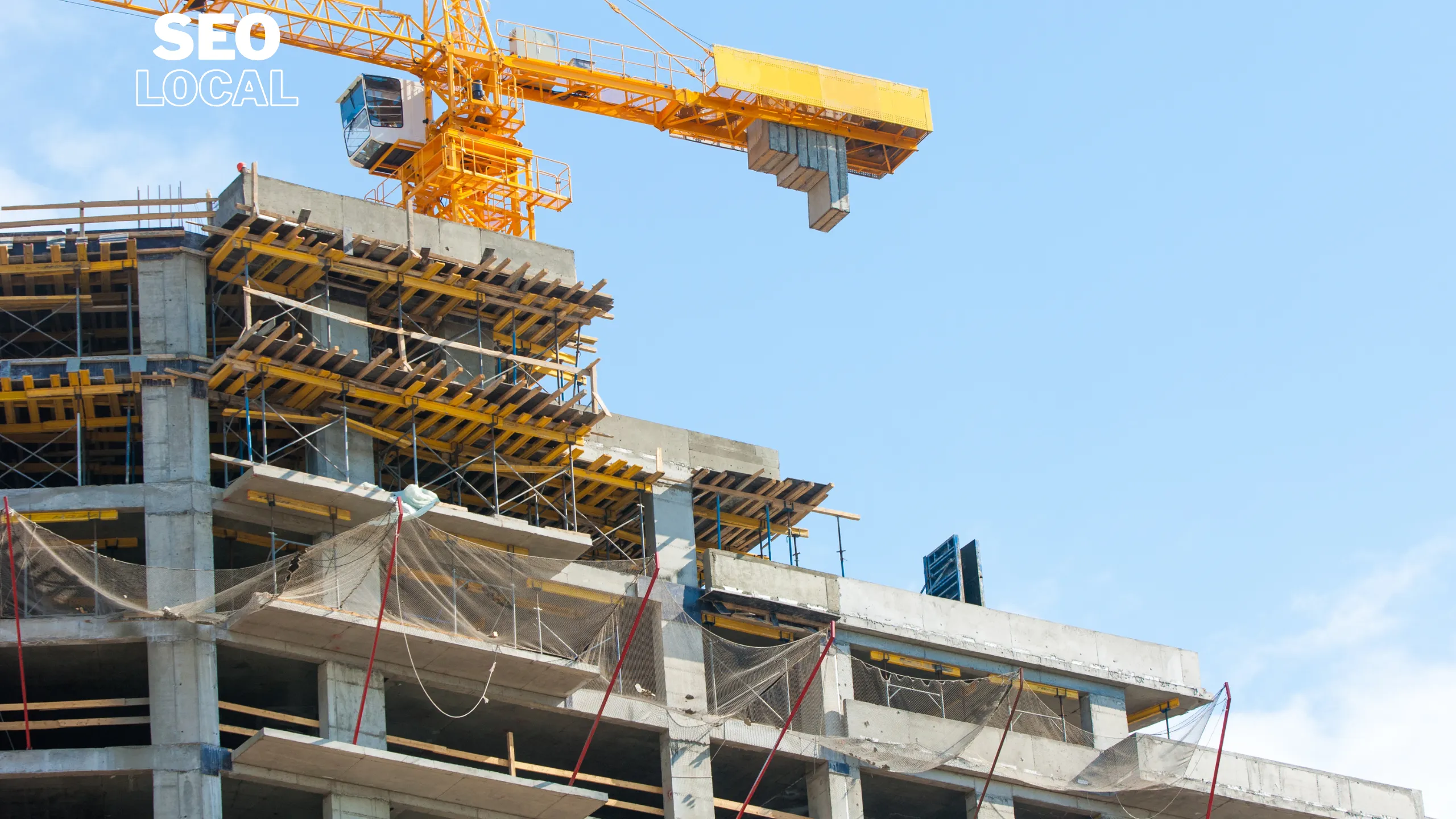 Un edificio en construcción con andamios y una grúa torre bajo un cielo azul
